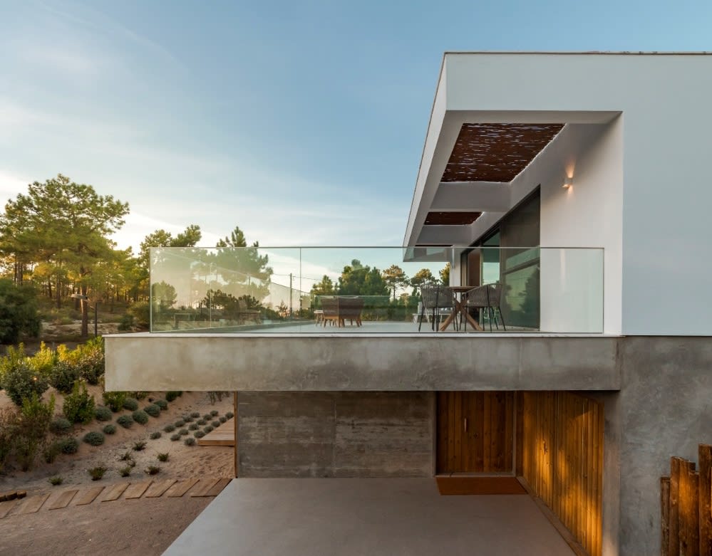 A modern villa’s balcony with a table and chairs