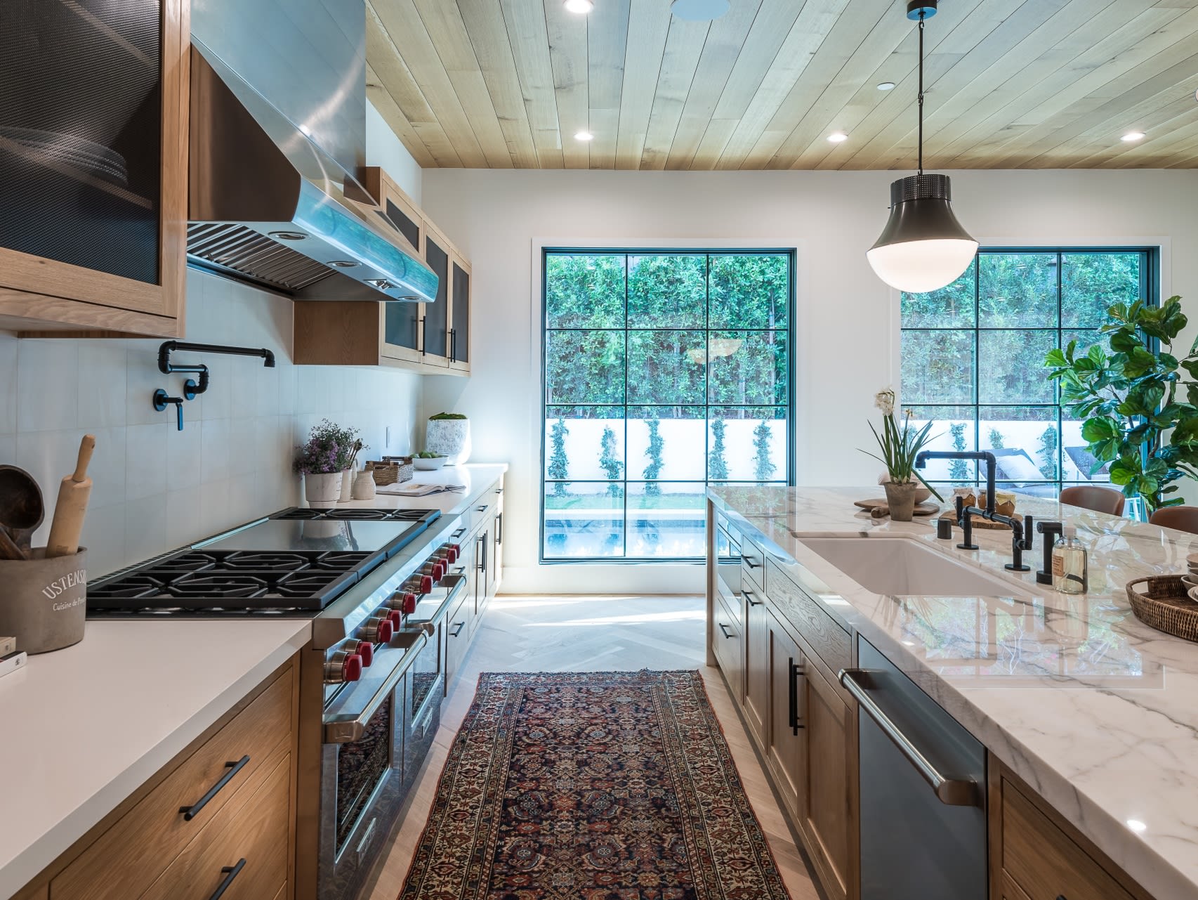 A modern kitchen with stainless steel appliances and white countertops.