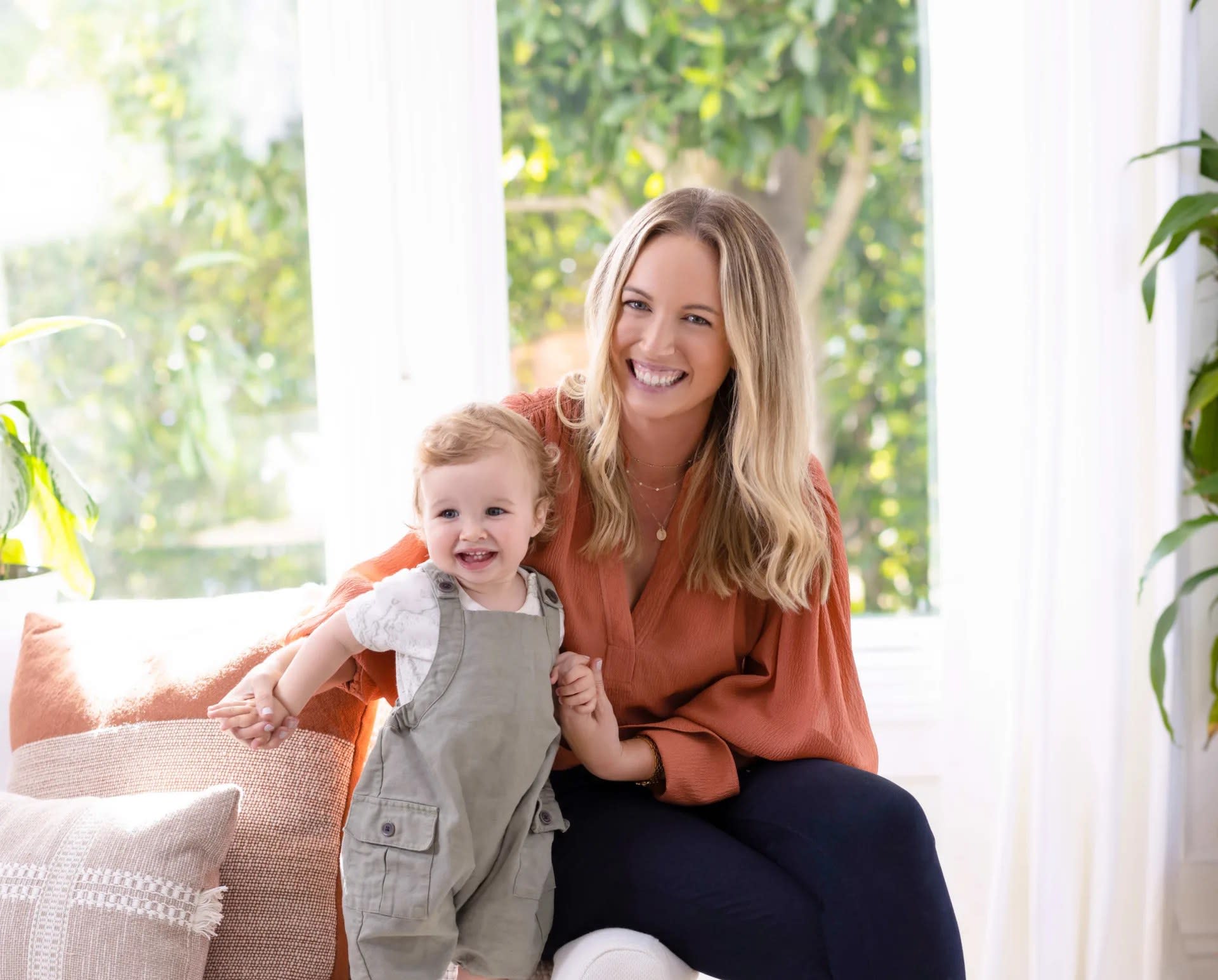 Claire sitting on a couch with her cute baby