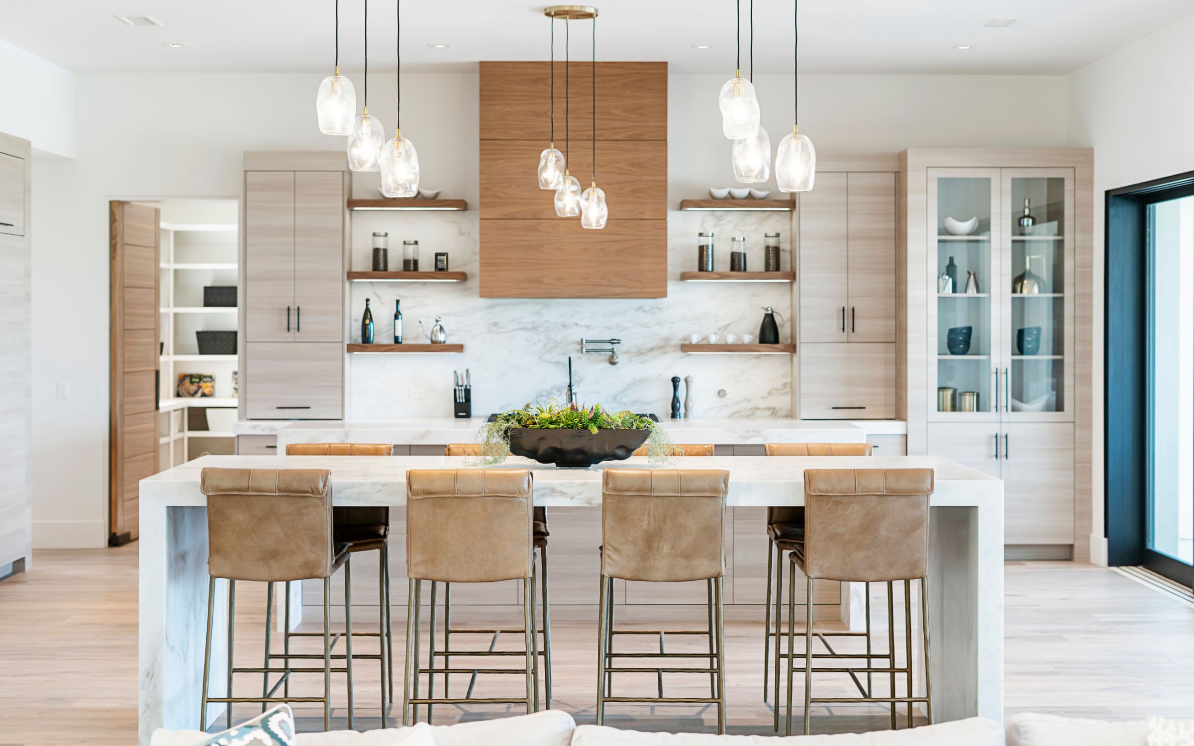A modern kitchen with white cabinets and a large white marble island