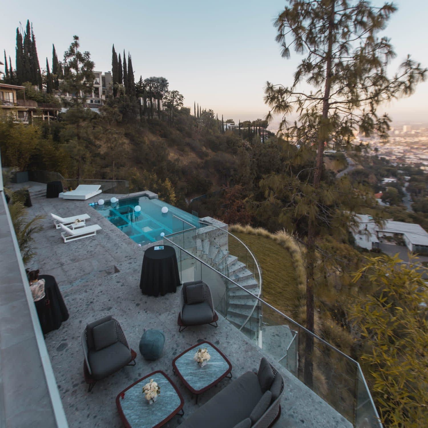 A patio with a swimming pool, chairs, and a table