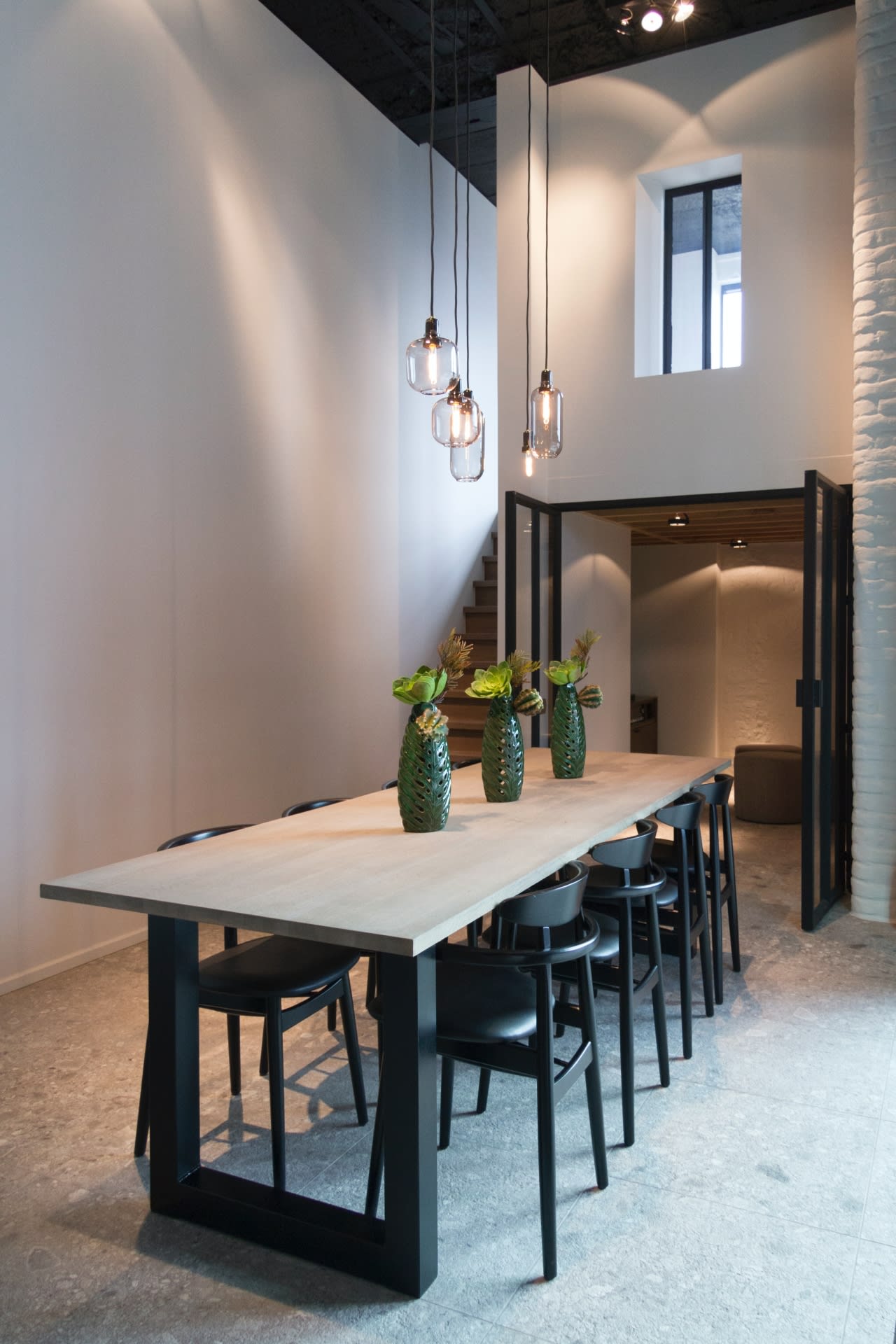 a dining table for eight people with three cactus design flower vases in the center