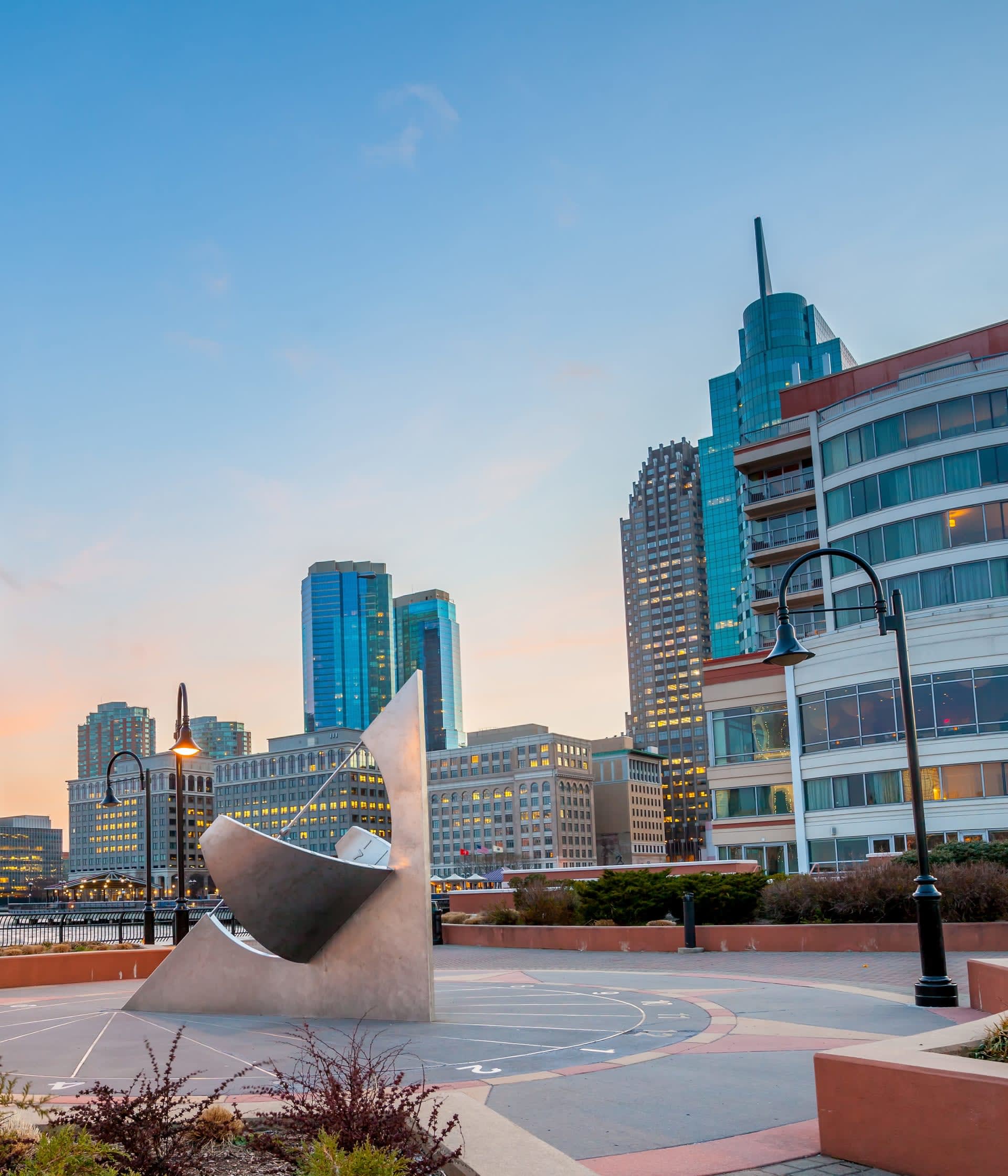 A giant sundial on the Hudson River Waterfront Walkway in Jersey City, with the Manhattan skyscrapers in the background.