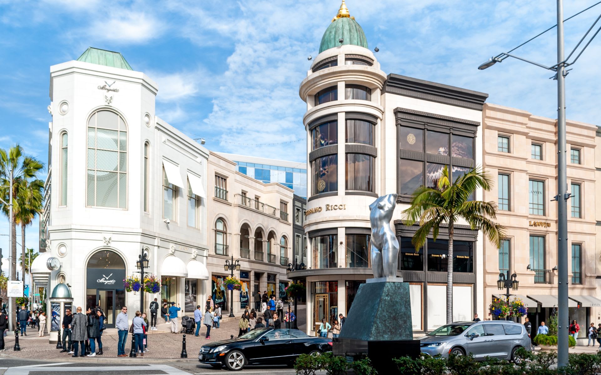 A shopping mall with a statue in front of it