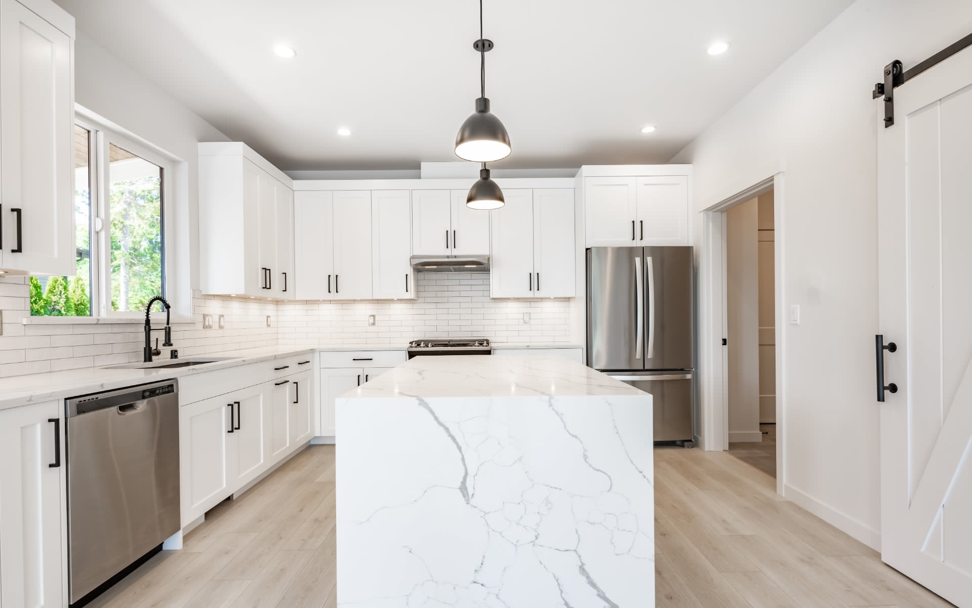 A kitchen with a large island and stainless steel appliances