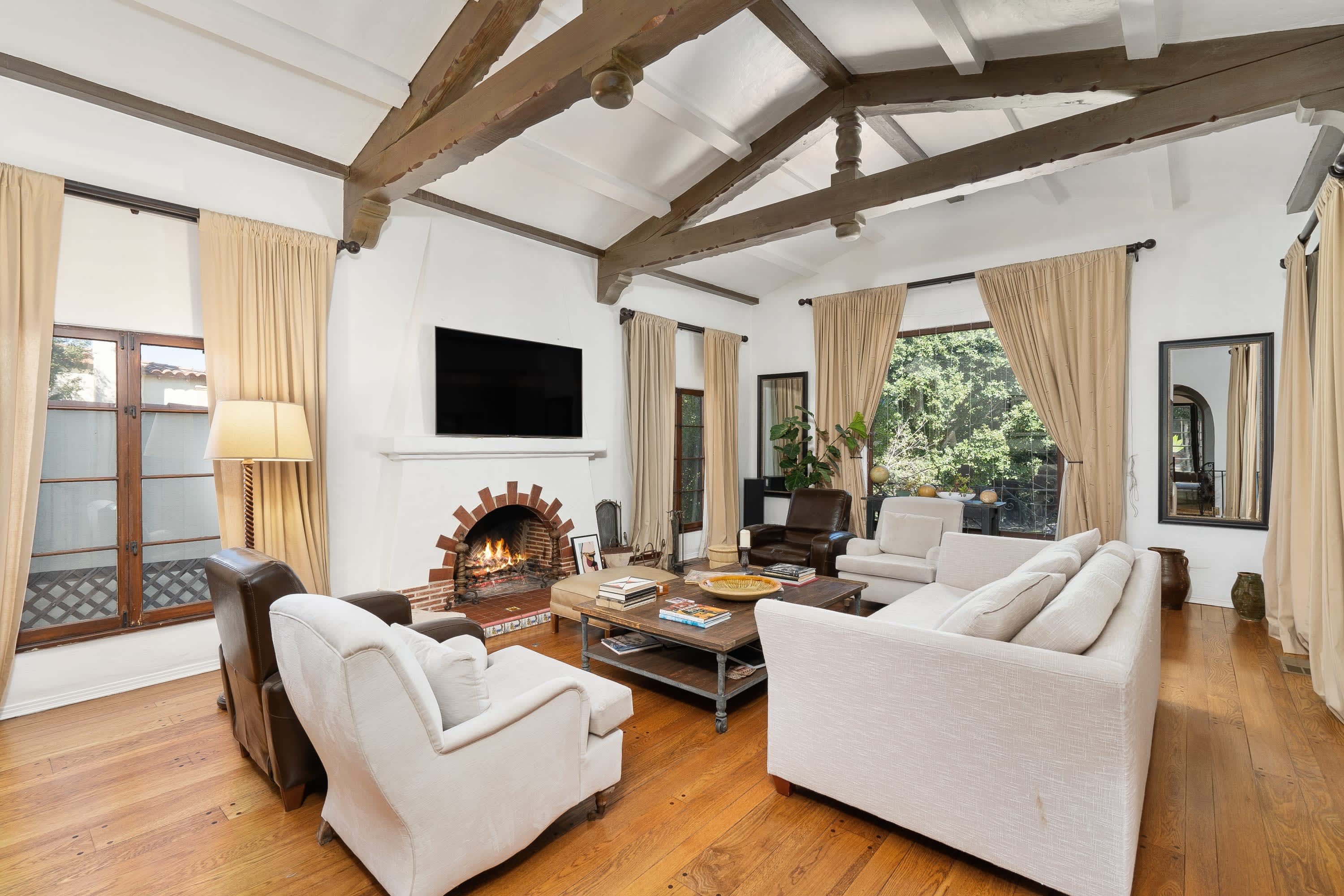 A cozy and inviting living room with a white couch, brown chairs, a wood coffee table, and a fireplace