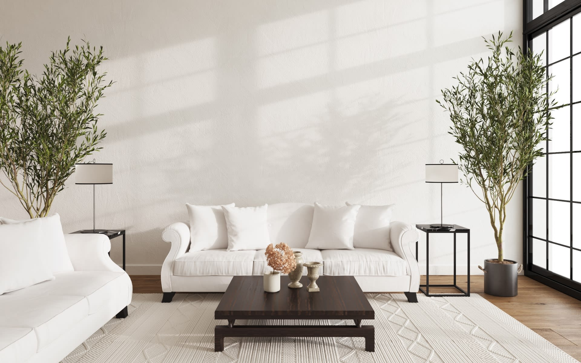 A well-lit, minimalist living room features two white sofas, one partially visible on the left and another centered.