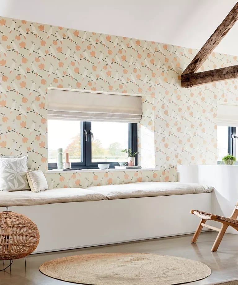 Bedroom with a built-in window seat, peach floral wallpaper, and an exposed dark timber beam.