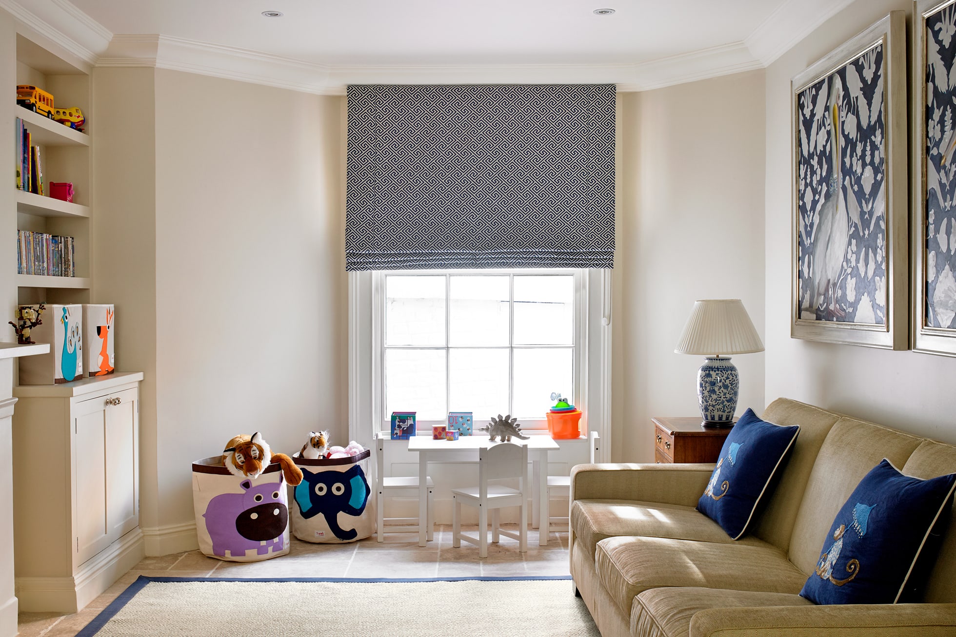 A living room with couch and blue roman shades on window