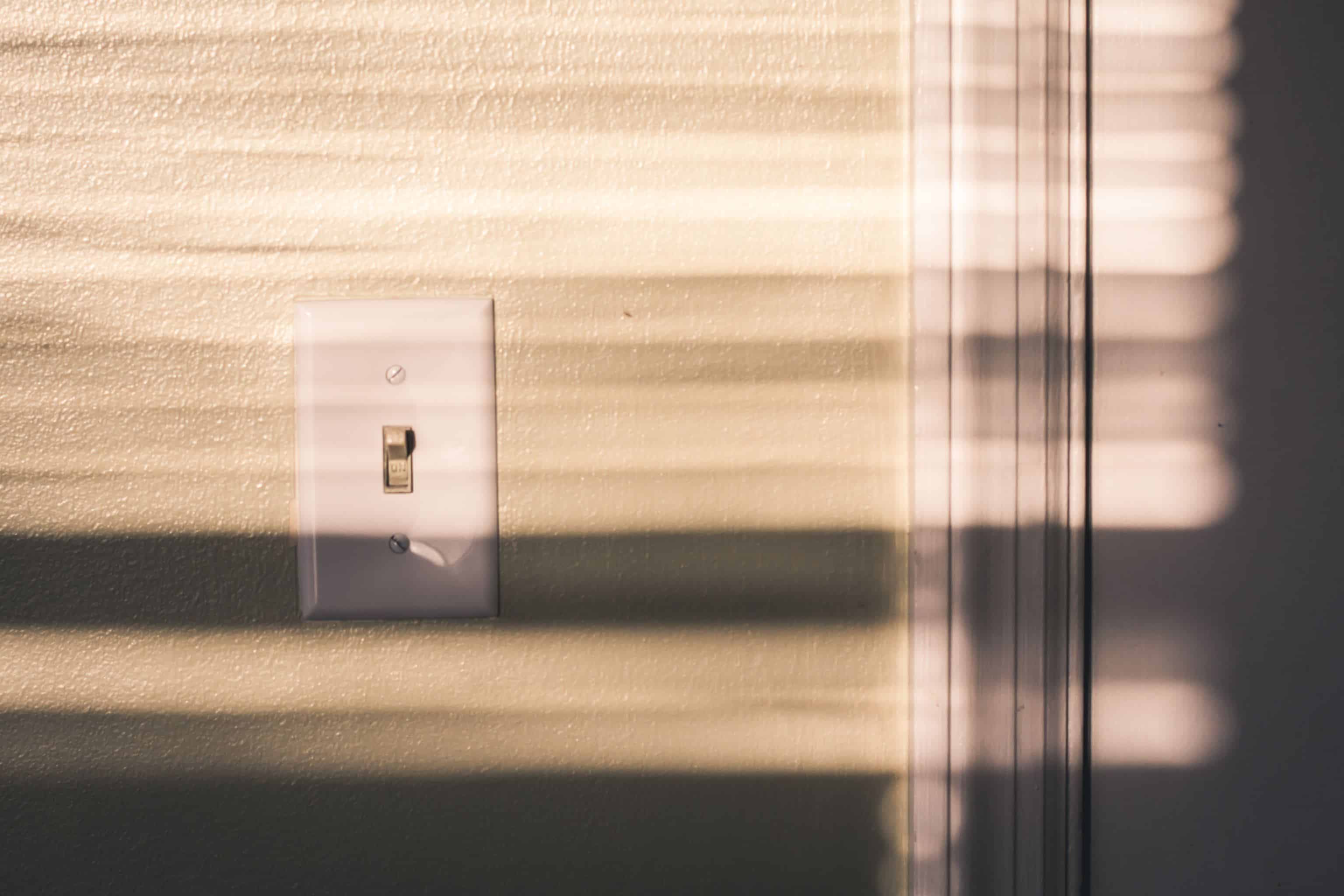 Afternoon light and shadows on a light switch inside a house