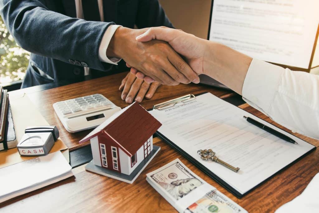 People shaking hands over a contract.