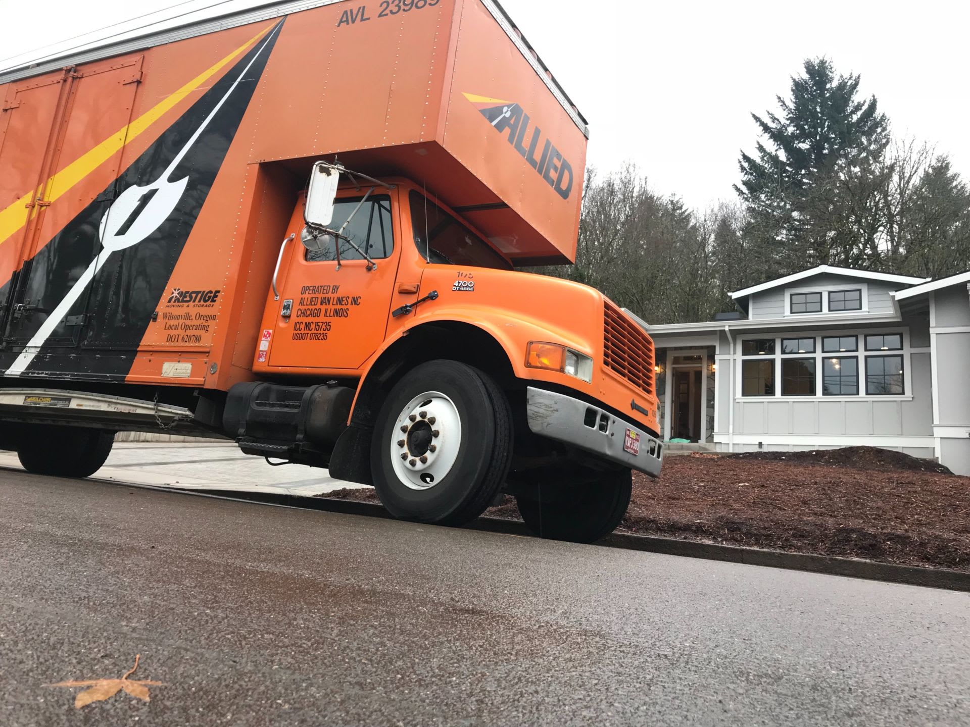 a large professional moving company van parked at the curb of a home