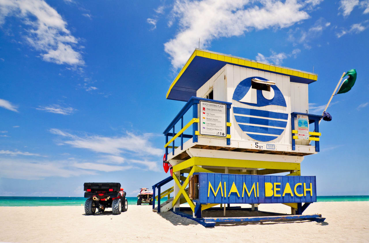 Lifeguard tower on a beach with a quad bike parked next to it