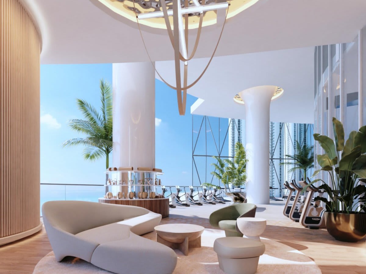 Fitness lounge with cardio machines, sculptural seating, tropical plants, and expansive water views.