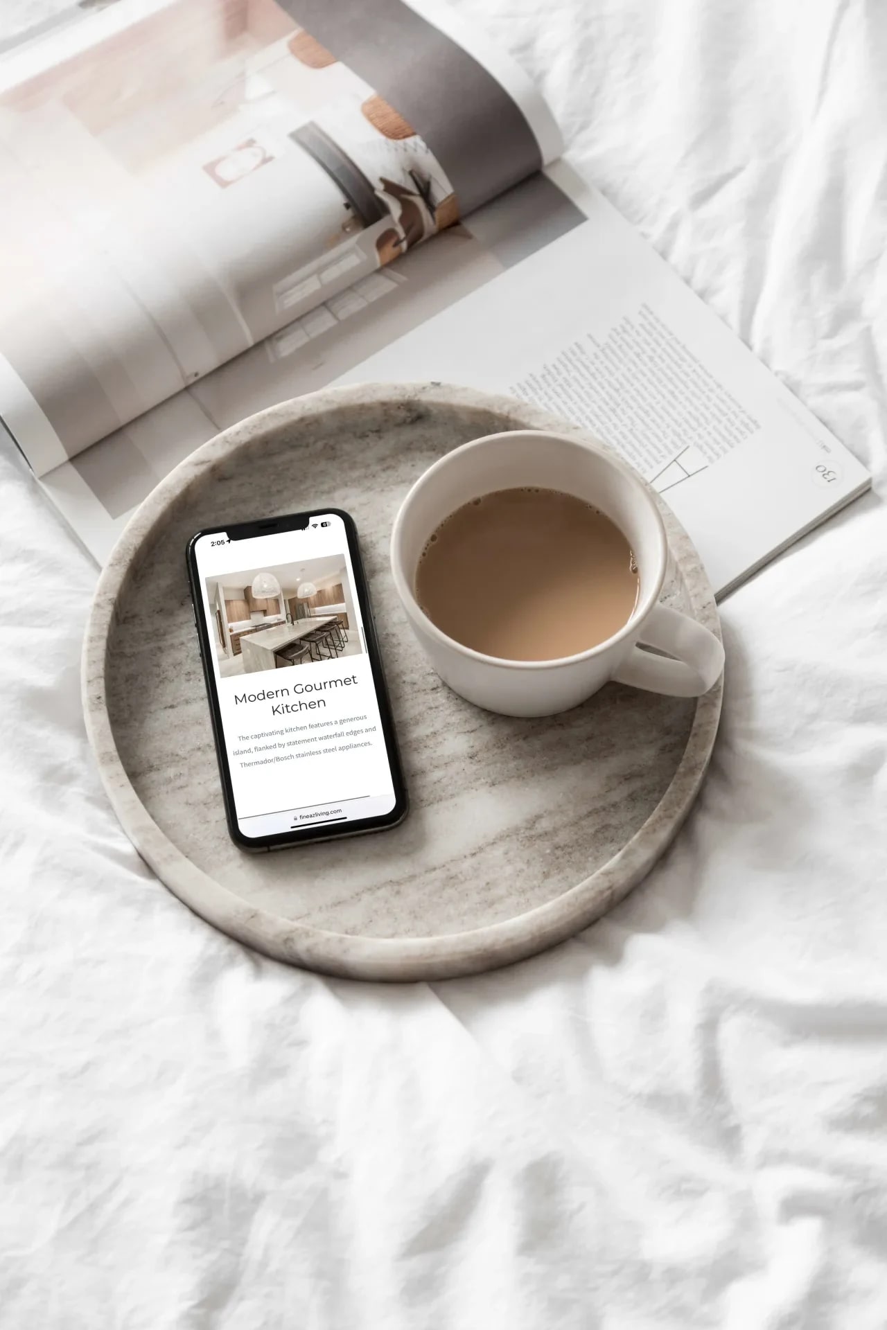 A luxurious bedroom setting: A cup of coffee and a magazine placed on a neatly made bed.