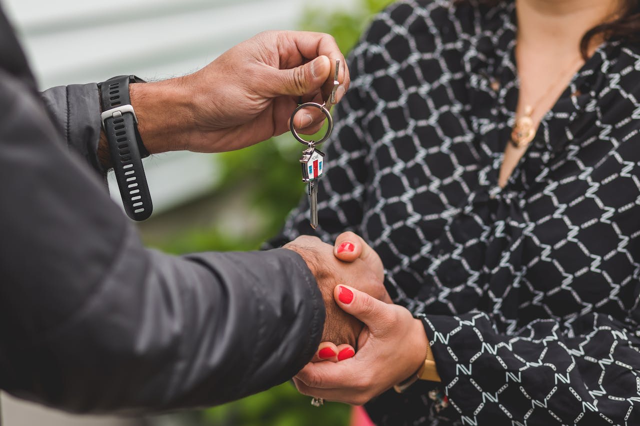 Person holding a silver house key.