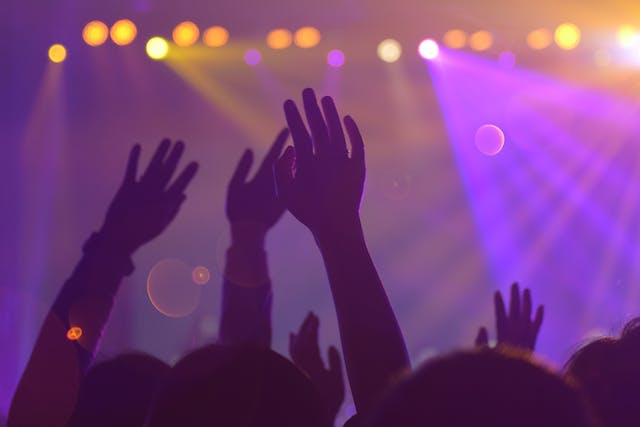 People with their hands in the air in a nightclub.