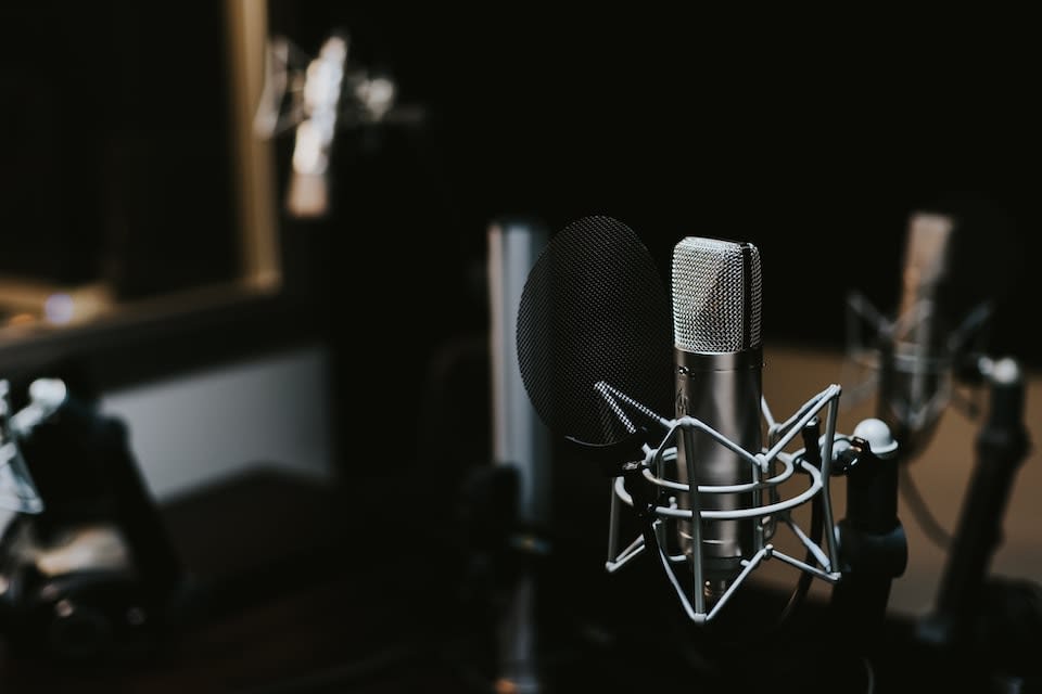 A close-up of a microphone in a recording studio.
