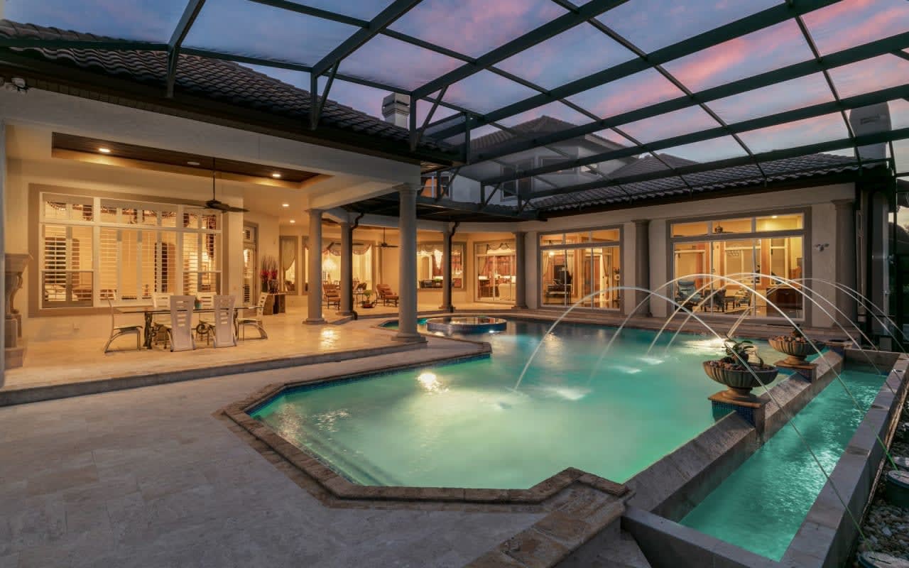 An elegant indoor pool glistening under warm lights in a luxurious home.