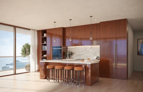 Condominium kitchen with walnut cabinetry, a marble backsplash, and windows overlooking the water.