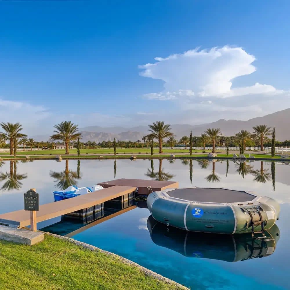 Serene boat dock with mountain views and lush green spaces - a luxury waterfront oasis.