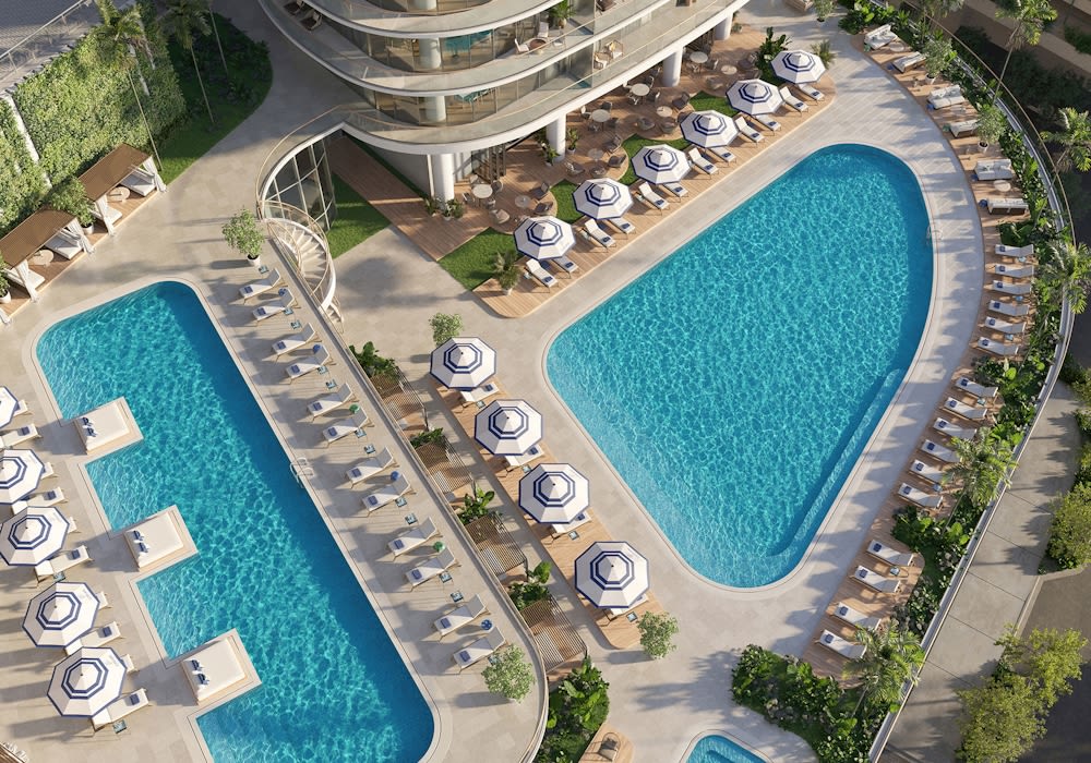 Cipriani Residences pool deck with two pools, loungers, and blue-and-white umbrellas.