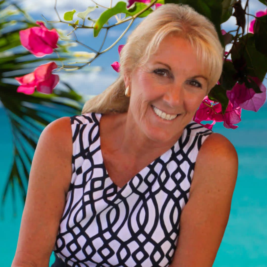 Jacquelyn Macken expert realtor standing beside a flowering plant