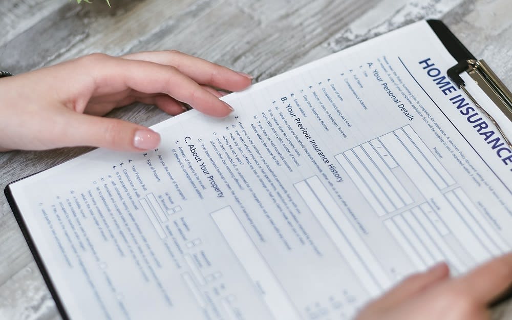 clipboard with "home insurance" written across the top of a form