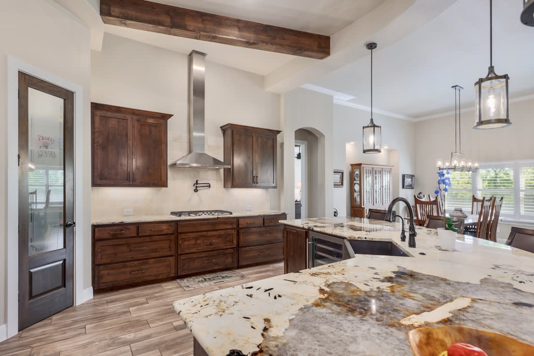 Walk in Pantry with glass door, Pot filler, vent hood, gas cooktop and cabinet drawers providing abundance of storage.