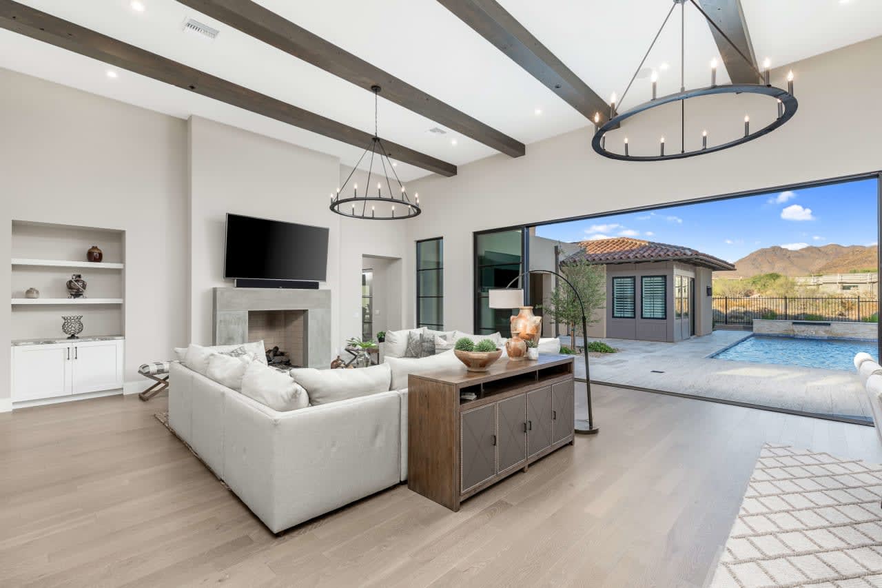 A modern living room with a plush couch and a large TV, bathed in warm light.