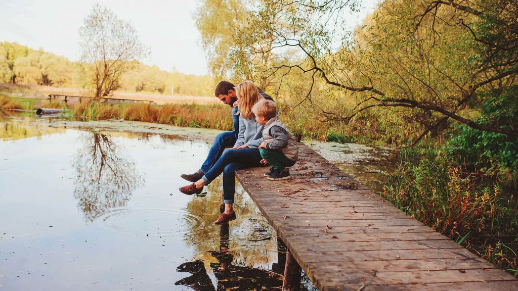 family sitting on a dock at a North Mianus pond