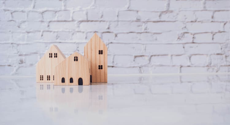 A collection of small wooden houses displayed against a clean white background, showcasing their intricate designs and textures.