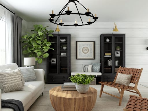 Living room with a white sofa, black cabinets, a round wooden coffee table, and a large leafy plant.