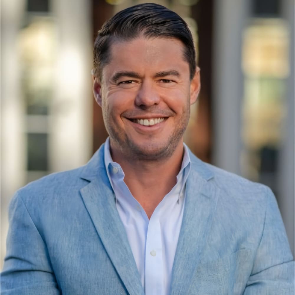 Patrick Seder, a real estate professional from The Mike Seder Group, looks sharp in a blue suit and white shirt.