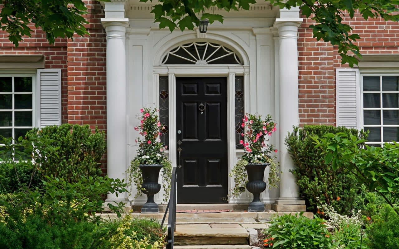 A warm and inviting brick house with a grand entrance.