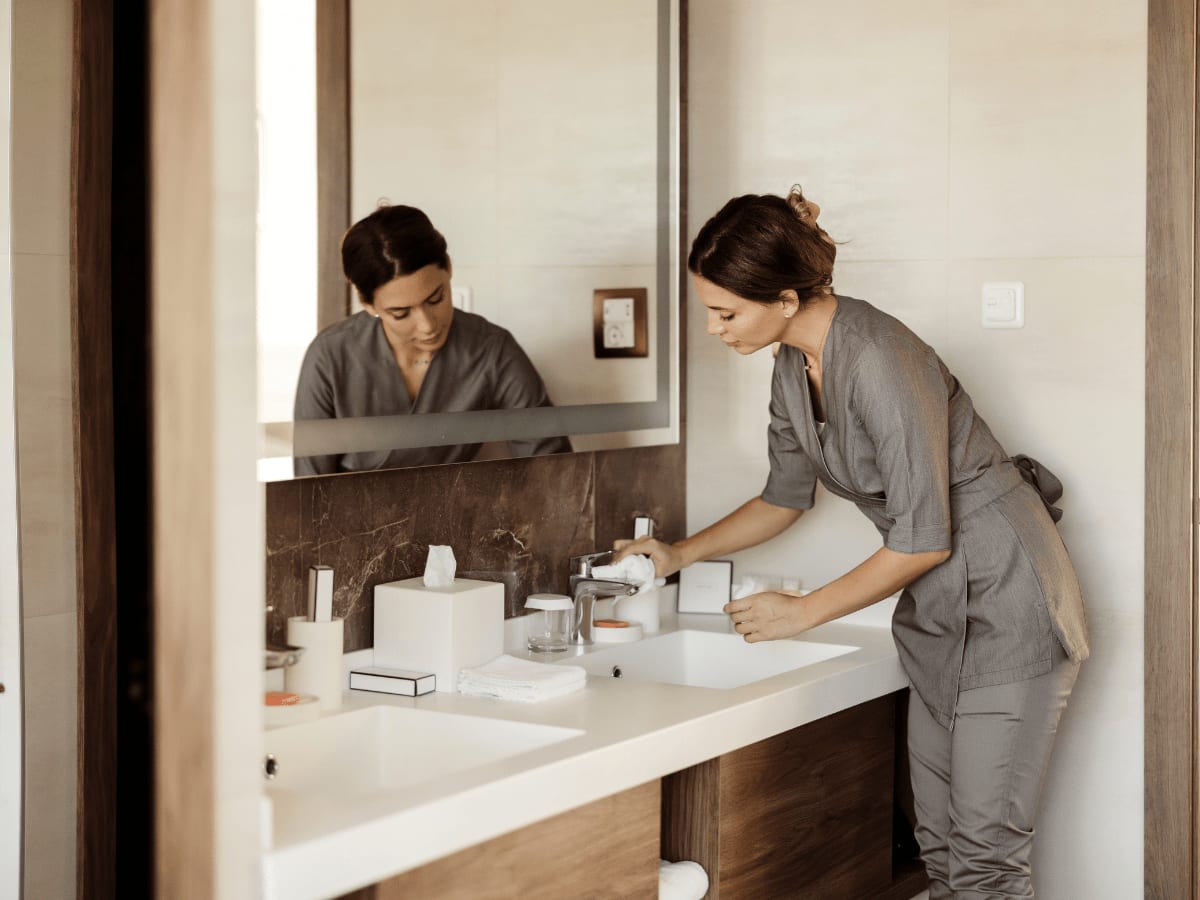 A Woman cleaning a bathroom sink