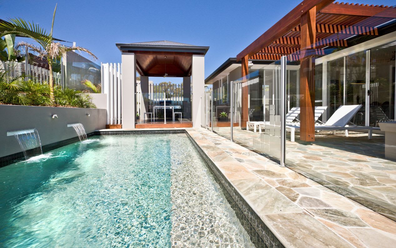 Swimming pool with glass fence and timber gazebo