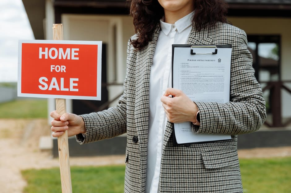 a woman carrying a signage Home for Sale