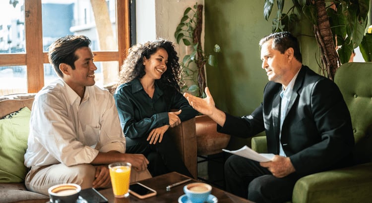 A group of three people having a discussion while seated