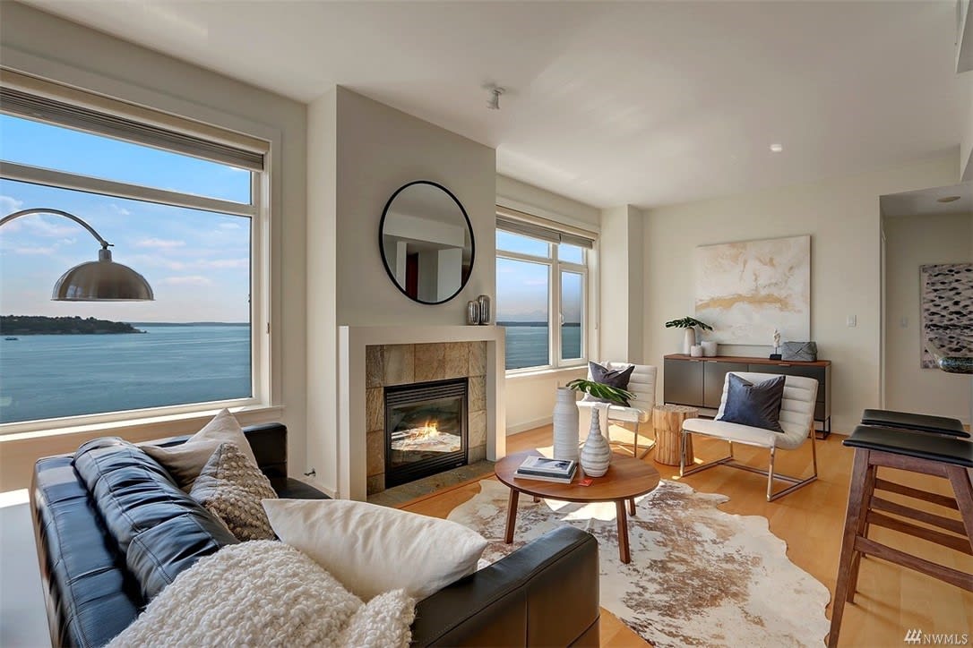 Chic luxury condo with cozy fireplace and serene sea views, bathed in natural light for stylish living.