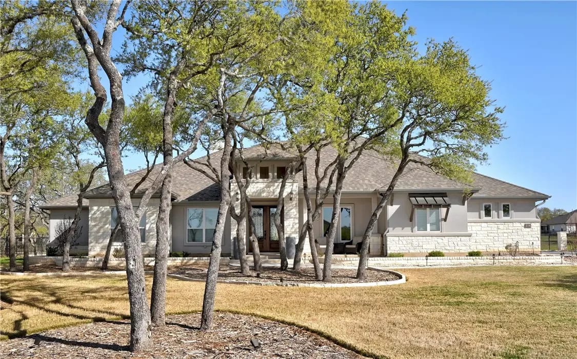 A modern house with a lot of trees in front of it.