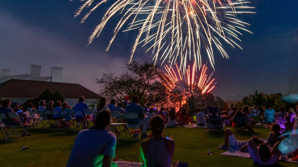 people watching fireworks over an Old Greenwich sky