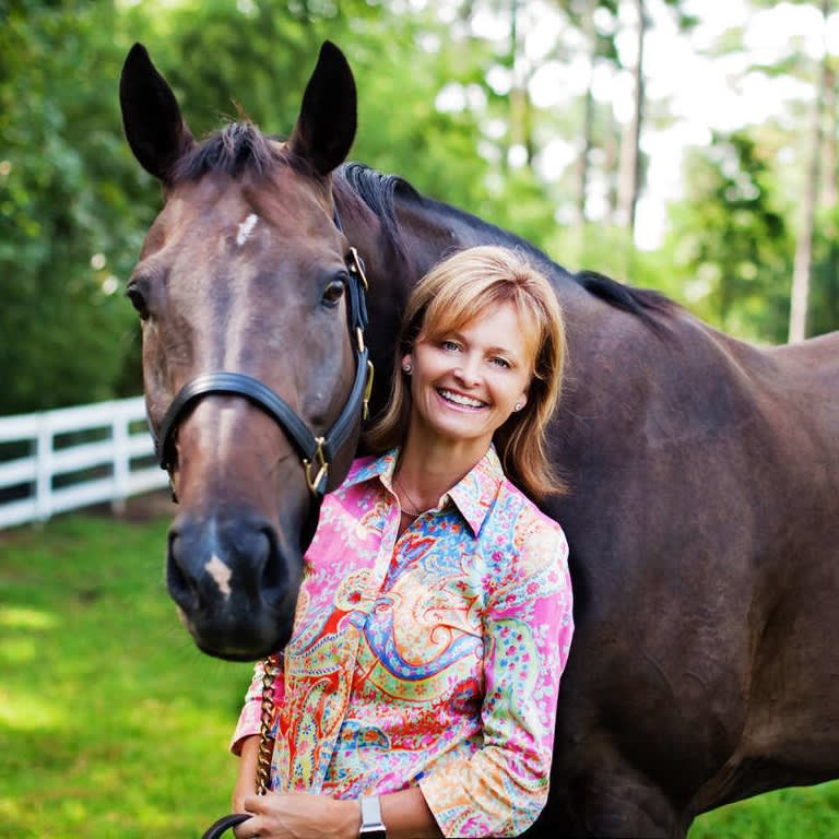 Smiling Jamie McDevitt with her horse at a luxury estate.