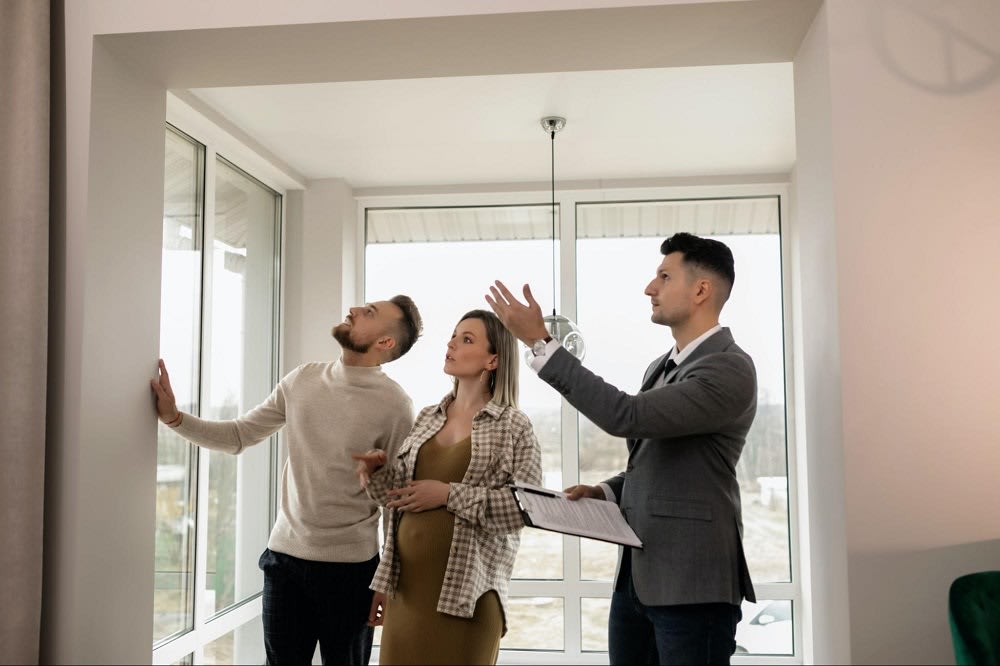 a couple is shown a home by an agent