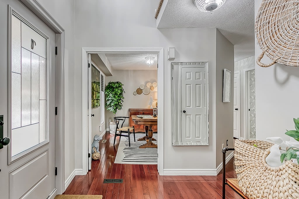 A long hallway with a wooden floor and a basket on the side.