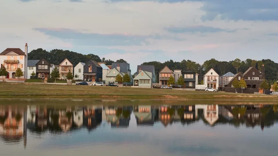 Trilith Homes overlooking a lake with the sun setting