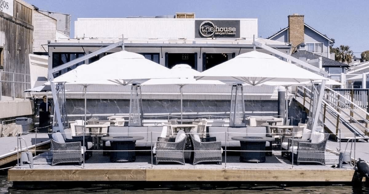 Outdoor seating area with umbrellas at The House restaurant in Newport Beach.