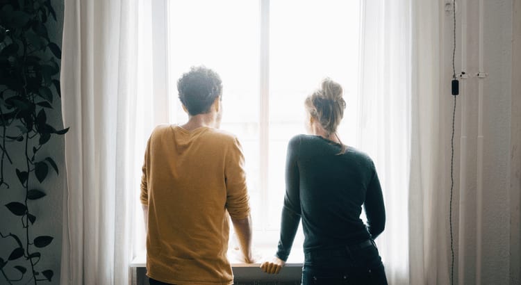 A couple gazes out the window, sharing a moment of reflection and connection as they observe the world outside.