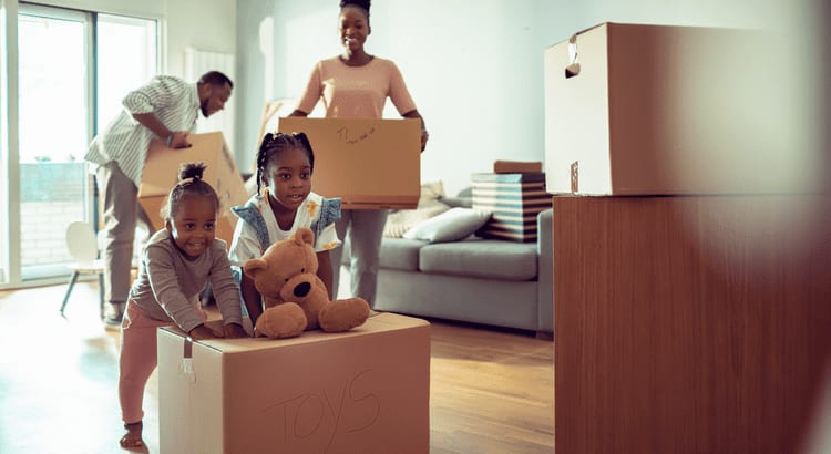 a family carrying their stuff inside their new home