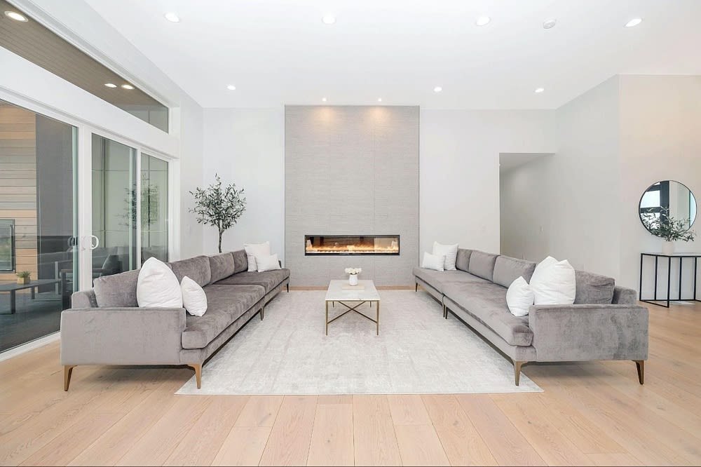 A living room with two couches on the side, a coffee table at the center of the room, and a fireplace on the back wall